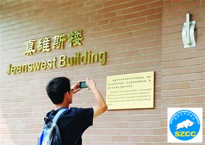 一名清华大学学生在拍摄“真维斯楼”的铭牌5月24日摄。
